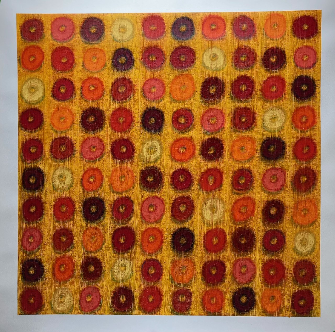 Autumn Loops — a grid of red, orange, pink, and cream loop shapes on a golden yellow ground